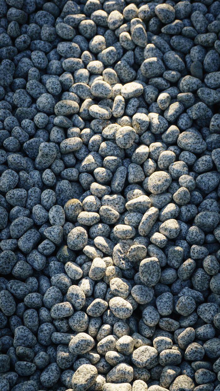 Services A collection of sunlit pebbles creating a natural and harmonious texture outdoors.
