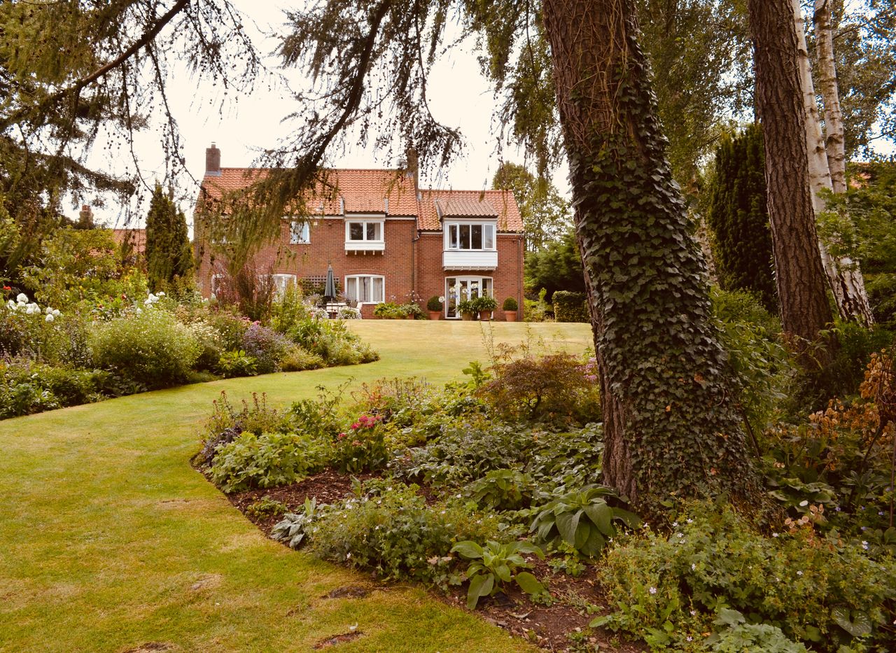 Services A classic English-style brick house surrounded by a lush, verdant garden.